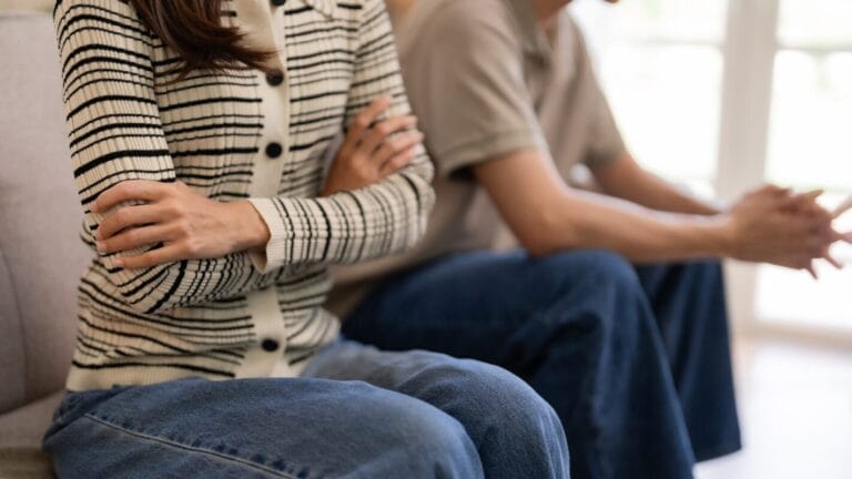 Man and woman sit next to each other, but do not touch