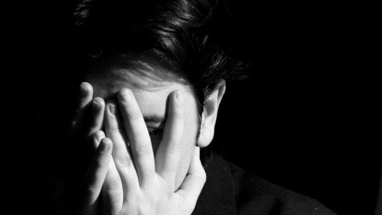 Man covering his face